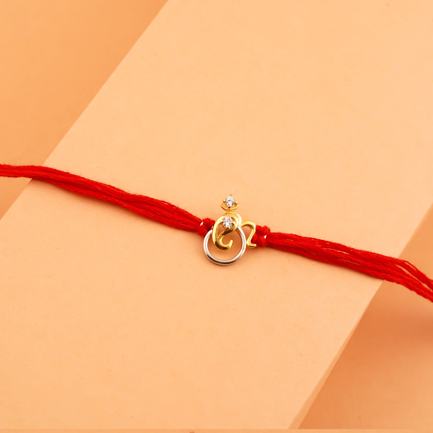 Silver Rakhi: Dual Tone Om Mini Ganesha Rakhi For Kids